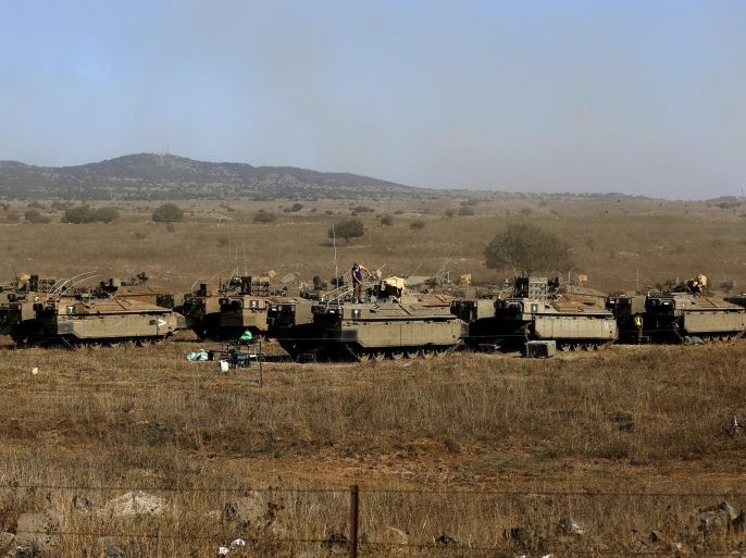 Israeli soldiers stand atop armoured personnel carriers stationed in the Israeli-annexed Golan Heights on August 21, 2015, after rockets fired from Syria to northern Israel. Israel launched artillery and air strikes against Syrian army positions in the Golan Heights on August 20 in response to rocket fire, military sources said. AFP PHOTO / AHMAD GHARABLI