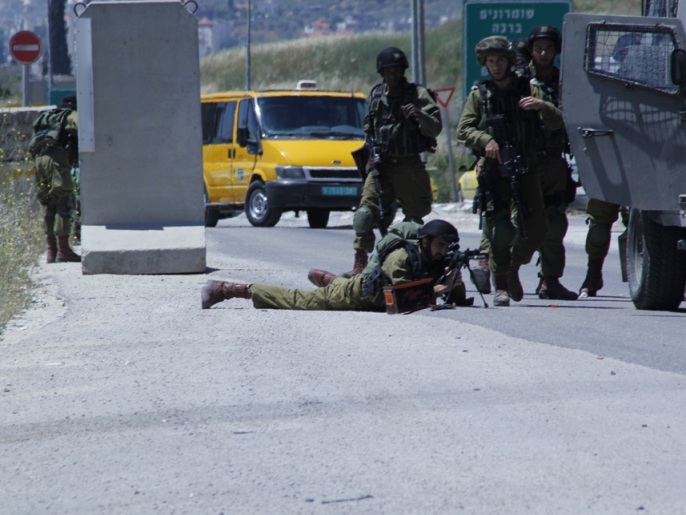 ‪جندي إسرائيلي يقنص الشبان الفلسطينيين عند حاجز حوارة جنوب نابلس‬ (الجزيرة)