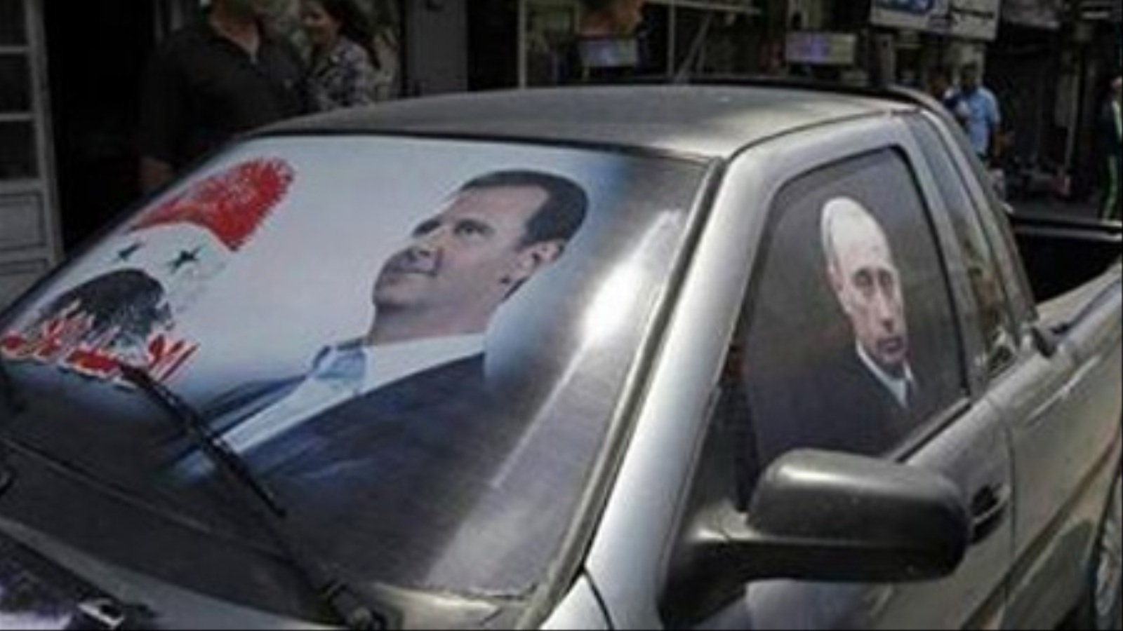 ‪‬ صورة الرئيس السوري ونظيره الروسي على إحدى السيارات في حماة(الجزيرة)