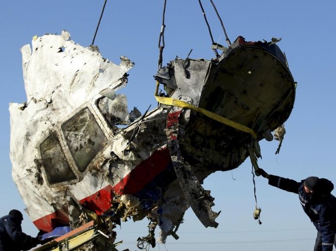 Local workers transport a piece of the Malaysia Airlines flight MH17 wreckage at the site of the plane crash near the village of Hrabove (Grabovo) in Donetsk region, eastern Ukraine in this November 20, 2014 file photo. MH17 was shot down on July 17, 2014 with 298 passengers on board. REUTERS/Antonio Bronic/Files FROM THE FILES - ONE YEAR ANNIVERSARY OF MH17 DOWNING. SEARCH "ANNIVERSARY MH17" TO FIND ALL 12 IMAGES