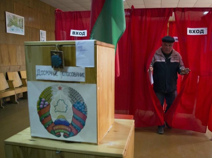 A man leaves a voting cabin at a polling station as early voting takes place ahead of Sunday's presidential election in the village of Kurkovo , 48 km (30 miles) east of Minsk, Belarus, Saturday, Oct. 10, 2015. (AP Photo/Dmitry Lovetsky)