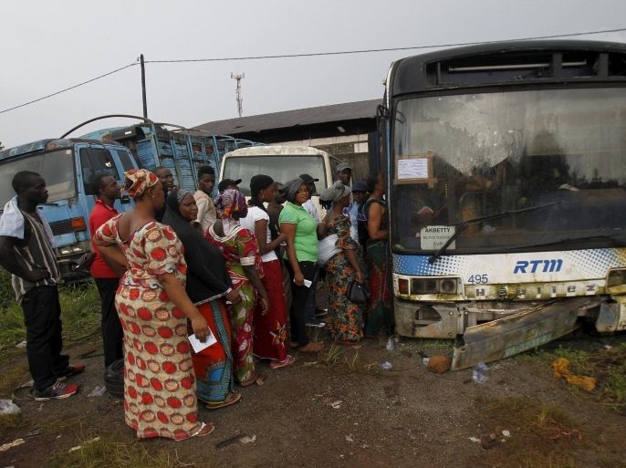 People wait to vote in an old bus which is used as a polling station during a presidential election in Conakry, Guinea October 11, 2015. Long lines formed in front of guarded polling booths across Guinea on Sunday as the West African country voted in its second free election in nearly 60 years since independence. REUTERS/Luc Gnago