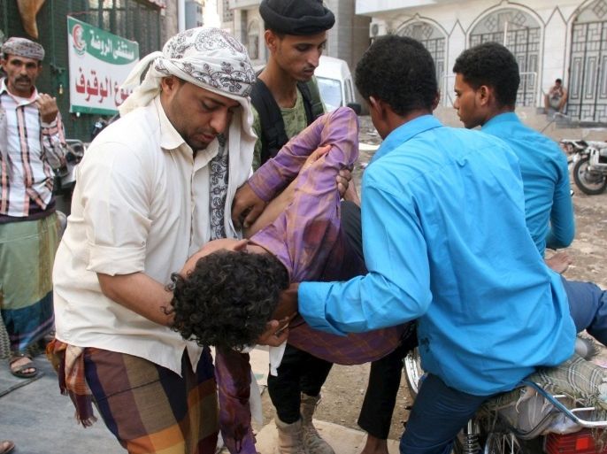 Volunteers carry a boy injured by a shell during fighting between pro-government militants and Houthi militia men in Yemen's southwestern city of Taiz September 29, 2015. REUTERS/Stringer