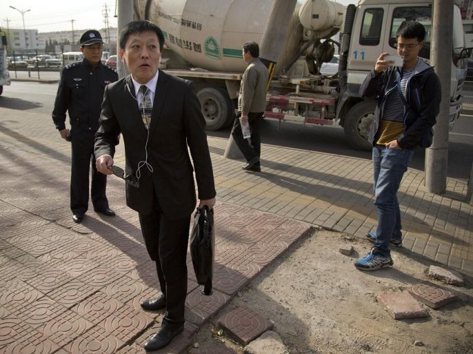 Shang Baojun, center, lawyer of veteran Chinese journalist Gao Yu, walks toward the Beijing No. 3 Intermediate Court in Beijing, Friday, April 17, 2015. Gao was sentenced to seven years in prison Friday for leaking a document detailing the Communist Party leadership's resolve to aggressively target civil society and press freedom as a threat to its monopoly on power. (AP Photo/Mark Schiefelbein)