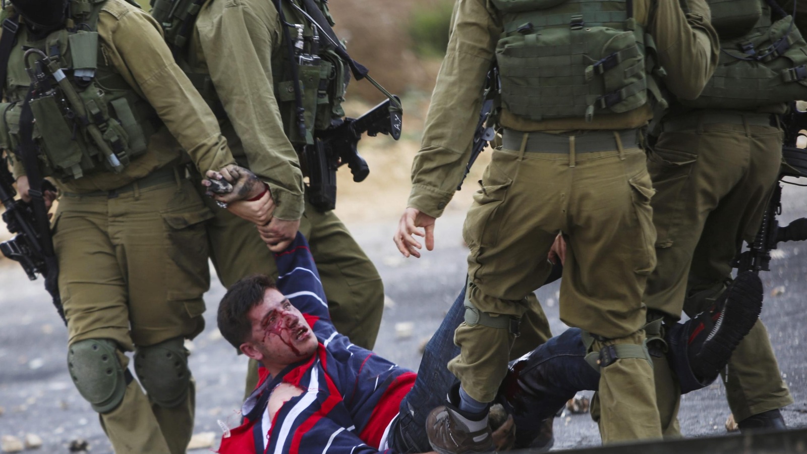 ‪جنود إسرائيليون يجرون شابا فلسطينيا أصابوه بالرصاص قرب رام الله‬ (الأوروبية)