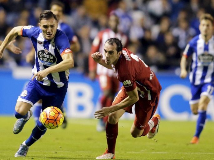 Deportivo Coruna's Lucas Perez (L) fights for the ball with Atletico Madrid's Diego Godin during their Spanish First Division soccer match at Riazor stadium in Coruna, Spain October 30, 2015. REUTERS/Miguel Vidal