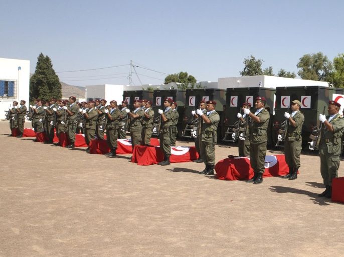 In this image provided by the TAP (Tunis Afrique Presse), a ceremony takes place for eight soldiers killed, Tuesday, July, 30, 2013 in Kasserine. Gunmen ambushed a Tunisian army patrol Monday in a mountainous border region known as an Islamic militant stronghold, killing at least eight soldiers, the presidential spokesman said.J ebel Chaambi, Tunisia's highest mountain at 1,500 meters (5,000 feet), is located near the Algerian border and the city of Kasserine, and was the site of an intensive military hunt for an al-Qaida-linked militant group during the spring. (AP Photo/Ali Louati, TAP)