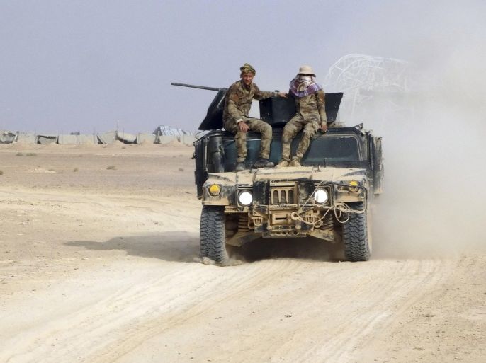 In this Thursday, Oct. 22, 2015 photo, Iraqi security forces patrol after regaining control of an area of Ramadi, the capital of Iraq's Anbar province, 70 miles (115 kilometers) west of Baghdad, Iraq. Coalition officials said that Iraqi security forces, backed by the paramilitary Popular Mobilization Forces and Iraqi federal police, and supported by airstrikes, continue to work to recapture and clear the western city of Ramadi and the city of Beiji, home to Iraq’s largest oil refinery. (AP Photo)