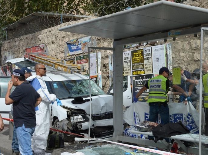 A handout picture provided by the Israeli Government Press Office (GPO) on 13 October shows Israeli emergency personnel working at the scene of an attack in Malchei Israel Street, Jerusalem, Israel, 13 October 2015. According to media reports, a suspect rammed a vehicle into a bus stop, got out of his car and stabbed bystanders, injuring at least three people, police say. In another incident, two attackers were shot dead by police after they opened fire upon and stabbed Israelis on a bus in Jerusalem, police spokesman Micky Rosenfeld said. EPA/AMOS BEN GERSHOM / GPO / HANDOUT