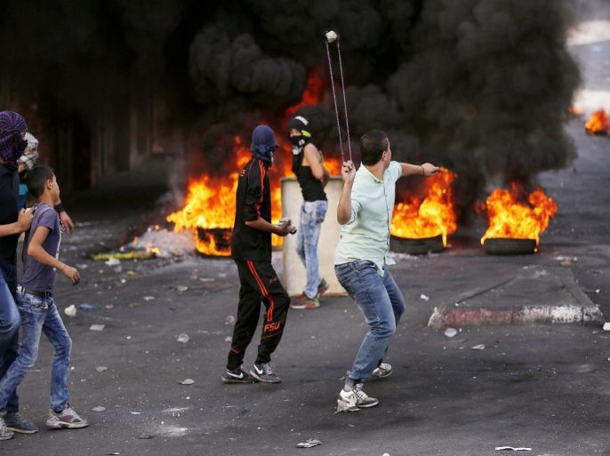 Palestinian protesters sling stones at Israeli soldiers during clashes in the West Bank city of Hebron, 22 October 2015. US Secretary of State John Kerry said on 22 October 2015 that he was 'cautiously encouraged' after several hours of talks with Israeli Prime Minister Benjamin Netanyahu on ending a month of Palestinian-Israeli violence.