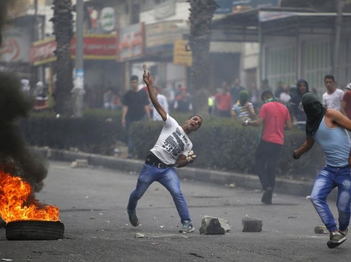 Palestinian protesters hurl stones at Israeli troops during clashes in the West Bank city of Hebron October 23, 2015. Palestinian factions called for mass rallies against Israel in the occupied West Bank and East Jerusalem in a "day of rage" on Friday, as world and regional powers pressed on with talks to try to end more than three weeks of bloodshed. REUTERS/Mussa Qawasma