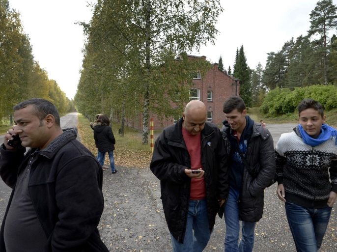 In this photo taken Friday, Sept. 25, 2015, Iraqi asylum seekers stand outside a refugee center located in the former army barracks, Lahti, Finland. Finland, on the northeastern frontier of the EU with vast expanses of forests and reindeer roaming the wilds of Lapland, with long, dark, cold winters, has not been a prime destination for population flows in Europe, but now hundreds of people are crossing daily from neighboring Sweden after traveling through that country by train or bus. (Markku Ulander/Lehtikuva via AP) FINLAND OUT, NO SALES
