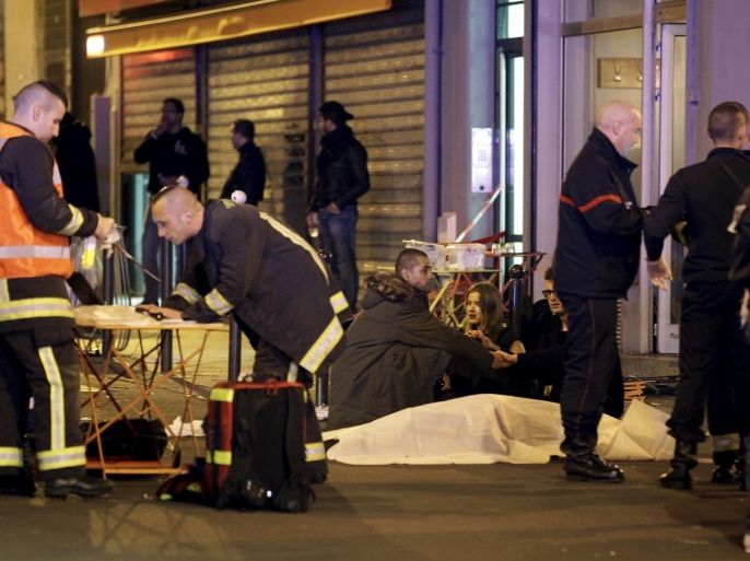 ATTENTION EDITORS - VISUAL COVERAGE OF SCENES OF INJURY OR DEATH A general view of the scene that shows rescue services personnel working near the covered bodies outside a restaurant following a shooting incident in Paris, France, November 13, 2015. REUTERS/Philippe Wojazer