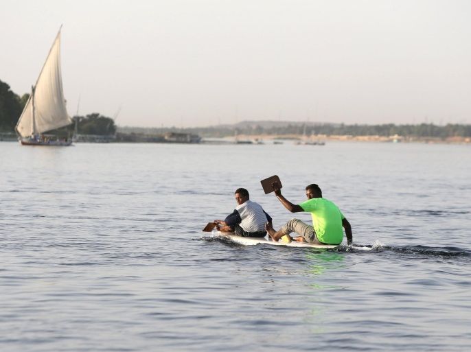 Nubian boys ride a raft, as they search for tourists to sing traditional Nubian songs, near the Nile river in Aswan on the road to the touristic Nubia, south of Egypt, October 1, 2015. For half a century, Egypt's Nubians have patiently lobbied the government in Cairo for a return to their homelands on the banks of the Nile, desperate to reclaim territory their ancestors first cultivated 3,000 years ago. Yet all their efforts to gain political influence have brought next to nothing. In Egypt's incoming parliament, which will be finalised after a second round of voting on Sunday, the Nubians will hold just one of 568 elected seats. Picture taken October 1, 2015 REUTERS/Mohamed Abd El Ghany.