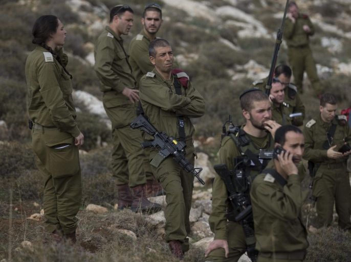 Israeli soldiers watch the rescue operation after a Israeli Army bus was involved in a fatal accident near the west bank Jewish settlement of Rimonim, 26 November 2015. Israeli army report that one female solders was killed and 40 other soldiers were wounded. The accident is not reported as terrorist attack related nor as any Palestinian conflict related attack.