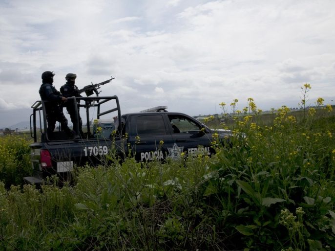 Mexican federal police guard near the Altiplano maximum security prison in Almoloya, west of Mexico City, Sunday, July 12, 2015. Mexico's most powerful drug lord, Joaquin "El Chapo" Guzman, escaped from a maximum security prison through a tunnel that opened into the shower area of his cell, the country's top security official announced. (AP Photo/Marco Ugarte)
