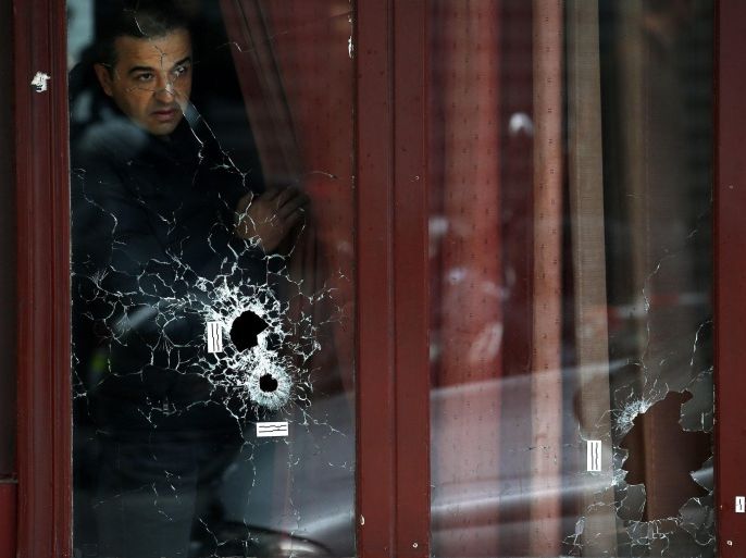 A man looks outside the Carillon cafe with bullets holes on the glasses, in Paris, France, 14 November 2015. At least 120 people have been killed in a series of attacks in Paris on 13 November, according to French officials. Eight assailants were killed, seven when they detonated their explosive belts, and one when he was shot by officers, police said. French President Francois Hollande says that the attacks in Paris were an 'act of war' carried out by the Islamic State extremist group.