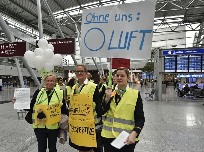 Lufthansa flight attendants protest at the airport in Duesseldorf, Germany, Friday, Nov. 5, 2015. The poster reads "without us - 0 air". Germany's flagship airline, Lufthansa, canceled 290 flights on Friday as cabin crew workers went on strike at Frankfurt and Duesseldorf airports. The carrier said the cancellations included 23 long-haul flights, and that overall some 37,500 passengers were affected. (AP Photo/Martin Meissner)