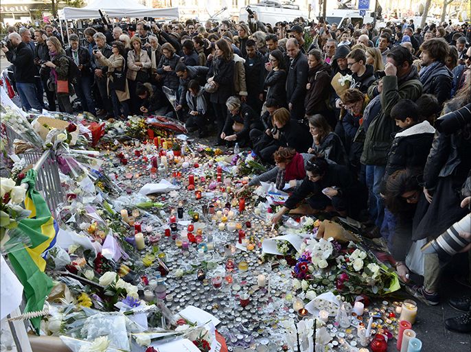 People gather in front of a memorial along a police cordon set-up close to the Bataclan concert hall on November 15, 2015, two days after a series of deadly attacks. Islamic State jihadists claimed a series of coordinated attacks by gunmen and suicide bombers in Paris on November 13 that killed at least 128 people in scenes of carnage at a concert hall, restaurants and the national stadium. AFP PHOTO / MIGUEL MEDINA