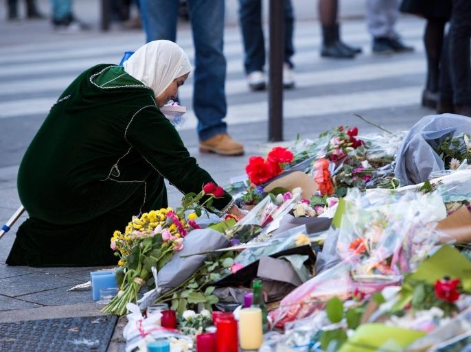 A woman lays flowers in front of the memorial set in front of the 'Petit Cambodge' restaurant in Paris, France, 15 November 2015. At least 129 people were killed in a series of terrorist attacks in Paris late 13 November.