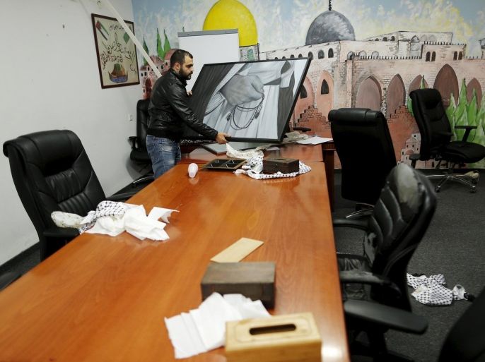 A man carries a photo inside the offices of the The Islamic Movement northern branch in Israel after Israel outlawed the Movement today in Umm al-Faham, northern Israel November 17, 2015. Israel on Tuesday outlawed an Islamist group it says has played a central role in stirring up violence over a Jerusalem holy site in a wave of bloodshed that began seven weeks ago. The decision by Israel's security cabinet, accompanied by police raids on the offices of the Islamic Movement's northern branch, were some of the strongest actions in years against a prominent organisation of the country's Arab minority. REUTERS/Ammar Awad