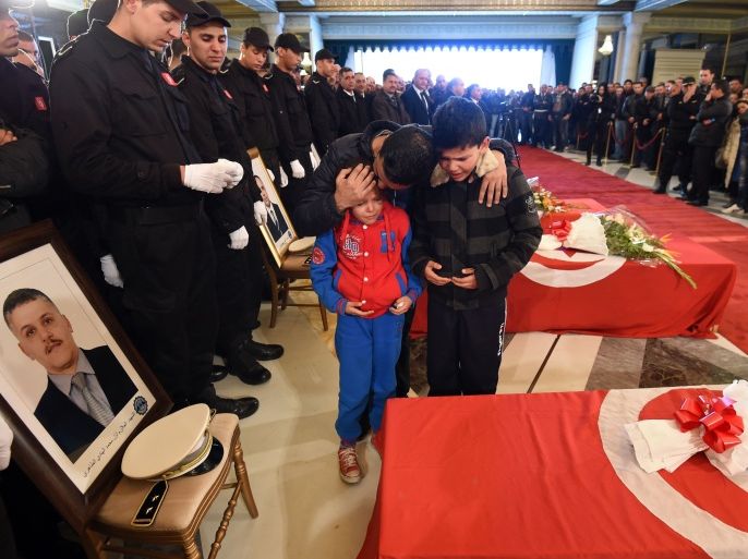 Family members of the presidential guards who were killed in a bomb blast on a bus in central Tunis the previous day mourn during an official ceremony to honour them at Carthage Palace in the Tunisian capital on November 25, 2015. The Islamic State group claimed the deadly bombing of a presidential guard bus in the Tunisian capital in a statement shared on jihadist social media accounts. AFP PHOTO / FETHI BELAID