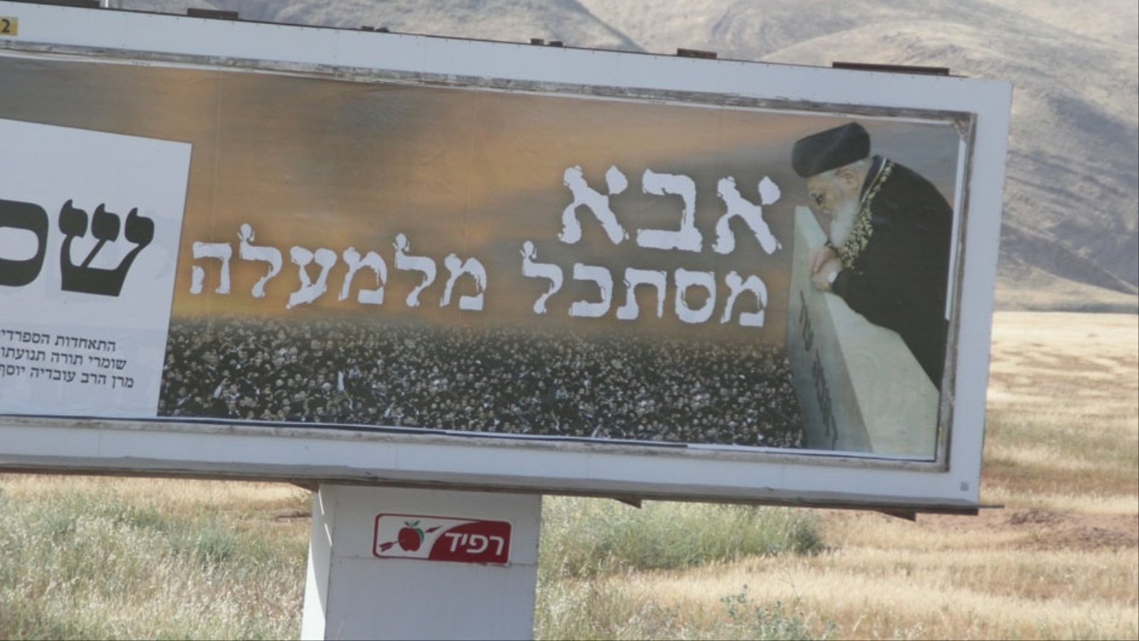 ‪لافتة تحمل صورة الحاخام عوفاديا يوسف تشير إلى أن المستوطنين يستوطنون الضفة انطلاقا من معتقدات دينية‬  (الجزيرة نت)