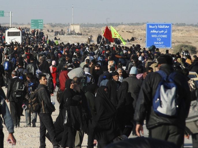 Iranian Shi'ite pilgrims walk on a road after entering Iraq through Wasit province at the Iraq-Iran border crossing, December 8, 2014. An influx of Iranian pilgrims over the past few days is seen at the Iraq-Iran border crossing as they head towards Iraq's holy city of Kerbala to attend the holy Shi'ite ritual of Arbaeen, which falls 40 days after the holy day of Ashura. REUTERS/Jaafer Abed (IRAQ - Tags: RELIGION SOCIETY)