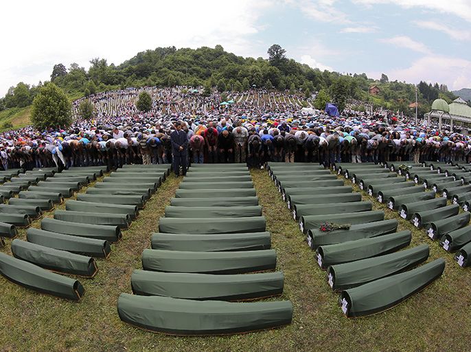 الموسوعة - epa03783998 Bosnian men and women pray during the burial of 409 newly-identified Bosnian Muslims at the Potocari Memorial Center in Srebrenica, Bosnia and Herzegovina, 11 July 2013, as part of a memorial ceremony to mark the 18th anniversary of the Srebrenica massacre, considered the worst atrocity of Bosnia's 1992-95 war. More than 8,000 Muslim men and boys were executed in the 1995 killing spree after Bosnian Serb forces overran the town. EPA/VALDRIN XHEMAJ