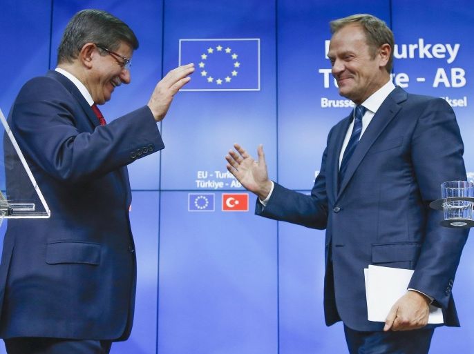 Turkish Prime Minister Ahmet Davutoglu (L) and European Council President Donald Tusk greet each other after a news conference following a EU-Turkey summit in Brussels, Belgium November 29, 2015. REUTERS/Yves Herman