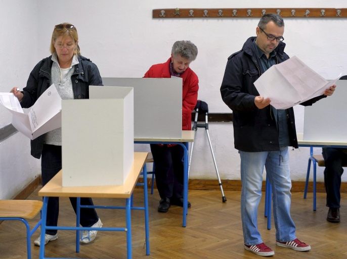 People look at ballot papers before casting a vote at a polling station during parliamentary election in Zagreb, Croatia, November 8, 2015. Croats began voting on Sunday in a parliamentary election, their first since joining the European Union in 2013, and the winner faces a tough task nurturing a fragile economic recovery and dealing with large numbers of migrants transiting the country. REUTERS/Antonio Bronic