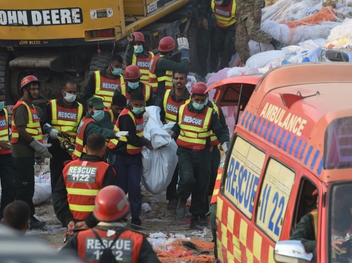 رجال إنقاذ باكستانيون يحلمون جثة شخص قضى خلال انهيار مصنع في مدينة لاهور عاصمة ولاية البنجاب الباكستانية نوفمبر 2015