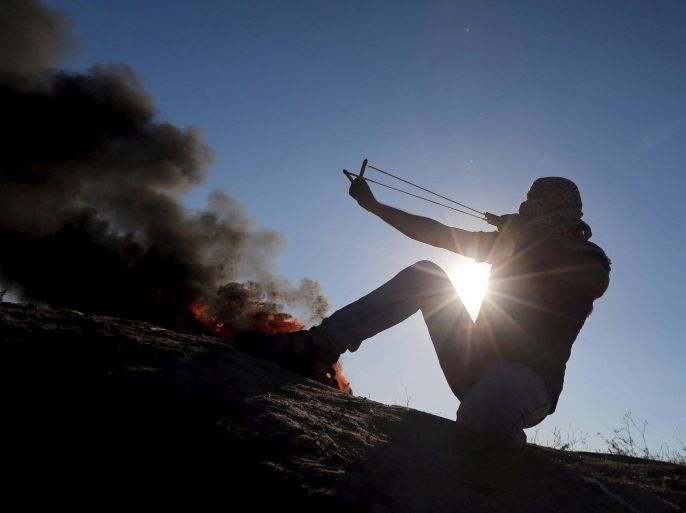 A Palestinian protester uses a slingshot to hurl stones towards Israeli troops during clashes near the border between Israel and Central Gaza Strip October 30, 2015. Knife-wielding Palestinians attacked Israelis in Jerusalem and the Israeli-occupied West Bank on Friday and one assailant was shot dead, police said, extending a wave of violence spurred in part by tensions over a Jerusalem holy site. REUTERS/Ibraheem Abu Mustafa
