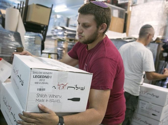 A worker carries boxes containing wine bottles for export at Shiloh Wineries, north of the West Bank city of Ramallah November 8, 2015. Few issues have caused more friction between Israel and the European Union than EU plans to impose labeling on goods produced in Jewish settlements on occupied land. And if Israel is right about the timing, the tensions could get worse." Shiloh Wineries, which exports half of the more than 100,000 bottles of wine it produces annually, built its business around its West Bank location of Shiloh - the ancient capital of Israel before Jerusalem. Picture taken November 8, 2015. REUTERS/Baz Ratner