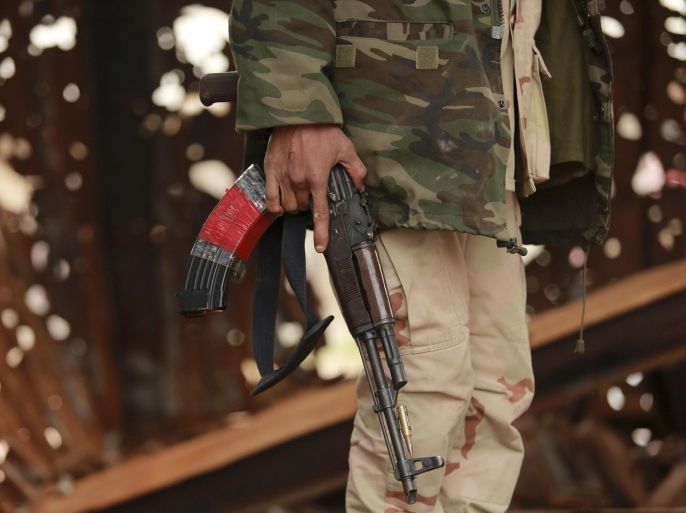 A member of the Libyan pro-government forces, backed by the locals, holds a weapon during street clashes with the Shura Council of Libyan Revolutionaries, an alliance of former anti-Gaddafi rebels who have joined forces with Islamist group Ansar al-Sharia, in Benghazi March 16, 2015. REUTERS/Esam Omran Al-Fetori (LIBYA - Tags: CIVIL UNREST POLITICS MILITARY CONFLICT)