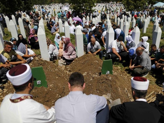 People sit around graves and tombstones at the Memorial Center Potocari, near Srebrenica, Bosnia and Herzegovina July 11, 2015. The bodies of the 136 recently identified victims of Srebrenica massacre are buried in Potocari during ceremonies to mark the 20th anniversary of the massacre. Abandoned by their U.N. protectors toward the end of a 1992-95 war, 8,000 Muslim men and boys were executed by Bosnian Serb forces over five July days, their bodies dumped in pits then dug up months later and scattered in smaller graves in a systematic effort to conceal the crime. REUTERS/Antonio Bronic