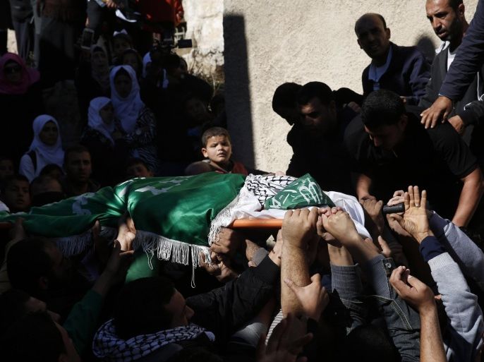 A Palestinian boy looks as mourners carry the body of 27-year-old Abdallah Shalaldeh, during his funeral in the West Bank village of Sa'ir, near Hebron, Thursday, Nov. 12, 2015. Israeli forces disguised in traditional Arab outfits, including one impersonating a pregnant woman and others appearing to have fake facial hair, burst into a hospital overnight Thursday, killing Shalaldeh during an arrest raid caught on video. (AP Photo/ Nasser Shiyoukhi)