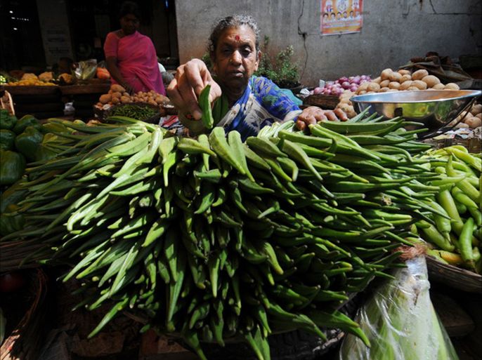 epa02055813 An Indian vegetable vendor puts a finishing touch to her impressive display of okra while she waits for customer at a vegetable market in southern Indian city of Bangalore on 26 February 2010