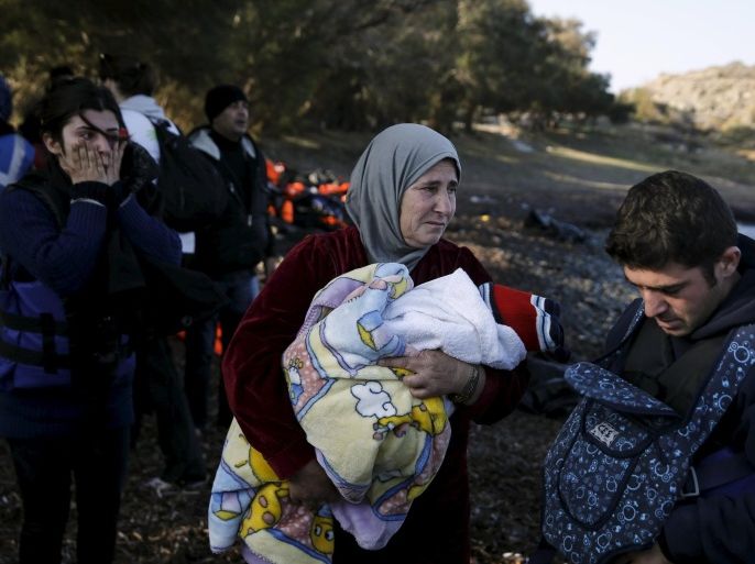 A Syrian refugee woman (C) cries as she holds a baby while refugees and migrants arrive on a boat on the Greek island of Lesbos, November 7, 2015. Since the start of the year, over 590,000 people have crossed into Greece, the frontline of a massive westward population shift from war-ravaged Syria and beyond. REUTERS/Alkis Konstantinidis
