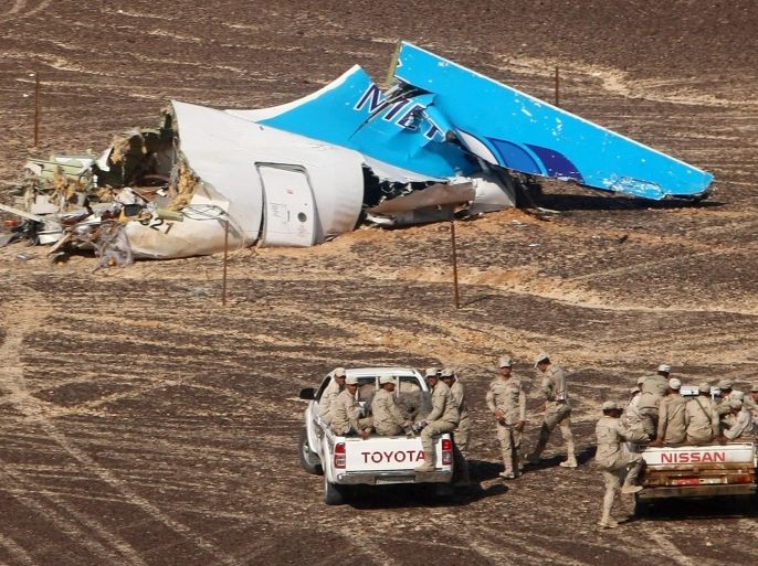 FILE - In this file photo made available Monday, Nov. 2, 2015, and provided by Russian Emergency Situations Ministry, Egyptian Military on cars approach a plane's tail at the wreckage of a passenger jet bound for St. Petersburg in Russia that crashed in Hassana, Egypt, on Sunday, Nov. 1, 2015. After the Islamic State group claimed the downing of the Russian plane in Egypt and deadly suicide bombings in Lebanon and Turkey, the Paris attacks appear to signal a fundamental shift in strategy toward a more global approach that experts suggest is likely to intensify. (Maxim Grigoriev/Russian Ministry for Emergency Situations via AP, FILE)