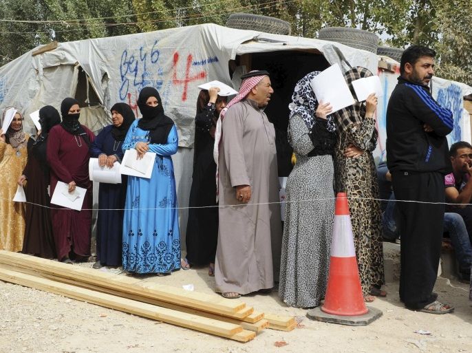 Syrian refugees queue to receive wood planks and tools donated by the United Nations High Commissioner for Refugees (UNHCR) to reinforce their tents, in preparation for winter conditions, at a makeshift settlement in Bar Elias in Lebanon's Bekaa Valley, October 23, 2015. REUTERS/Hassan Abdallah EDITORIAL USE ONLY. NO RESALES. NO ARCHIVE