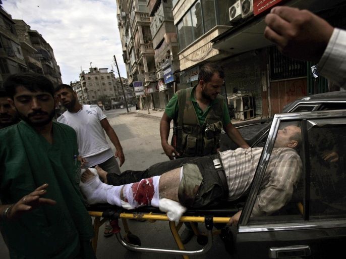 Syrian rebels and medical staff put an injured man into a car after being shot by government forces, outside a hospital in Aleppo, Syria, Tuesday, Sept. 11, 2012. (AP Photo/Muhammed Muheisen)