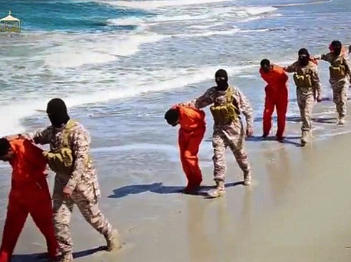 FOR USE AS DESIRED, YEAR END PHOTOS - FILE - EDS NOTE: GRAPHIC CONTENT - In this undated image made from a video released by Islamic State militants on April 19, 2015, which has been verified and is consistent with other AP reporting, members of an IS affiliate walk captured Ethiopian Christians along a beach in Libya. The video purportedly shows two groups of captives: one held by an IS affiliate in eastern Libya and the other by an affiliate in the south. A masked militant delivers a long statement before the video switches between footage that purportedly shows the captives in the south being shot dead and the captives in the east being beheaded on a beach. (Militant video via AP, File)