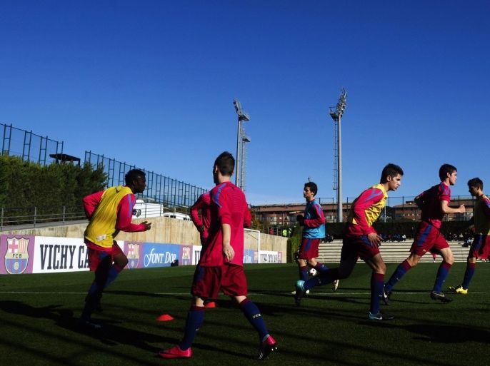 FILE - In this Jan. 8, 2011 file photo, Barcelona youth players from 'La Masia' football academy warm up at the Barcelona FC's Joan Gamper training camp in San Joan Despi, Spain. The Court of Arbitration for Sport on Tuesday Dec. 30, 2014 dismissed Barcelona's appeal and upheld the transfer ban FIFA imposed on the club for infringing regulations on registering minors as youth players. CAS said in a statement that “Barcelona had breached the rules regarding the protection of minors and the registration of minors attending football academies.” The ruling means Barcelona will be barred from signing any players in 2015. Barcelona is renowned for training and educating young players such as Lionel Messi and Andres Iniesta at it's La Masia academy, in the hope they develop the talent to graduate to the senior team. (AP Photo/Manu Fernandez, File)