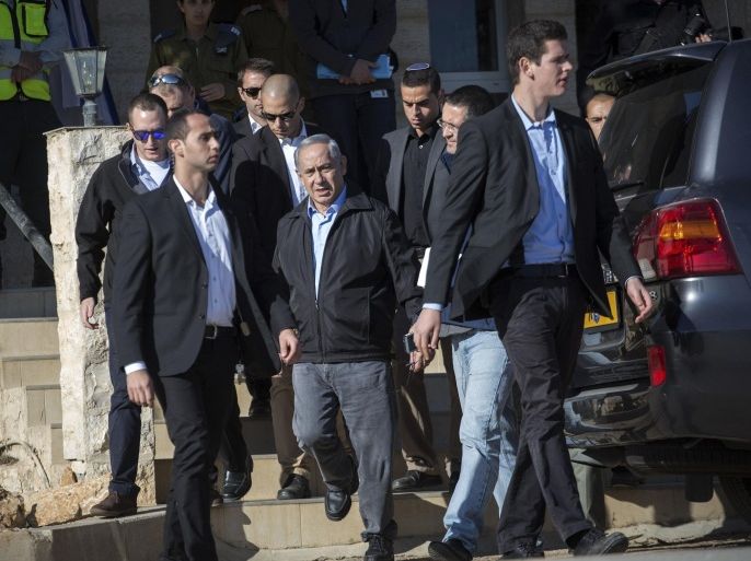 Israel's Prime Minister Benjamin Netanyahu, center, walks, escorted by security, during a visit to an army base near the Gush Etzion bloc of Jewish settlements in the West Bank Monday, Nov. 23, 2015. Netanyahu pledged to keep up Israel’s tough hand against Palestinians attackers. (Emil Salman/Pool via AP)
