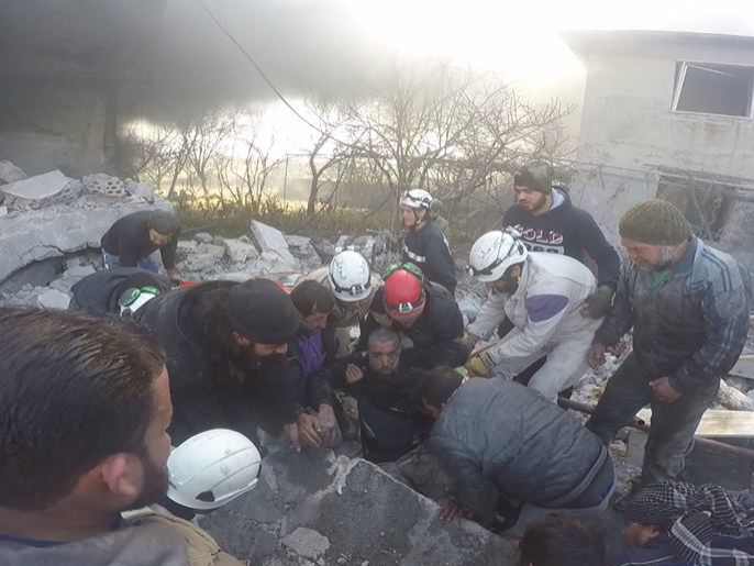 مواطنون بريف اللاذقية ينتشلون أحد ضحايا القصف روسي على جبل الأكراد من بين أنقاض أحد المباني(الجزيرة