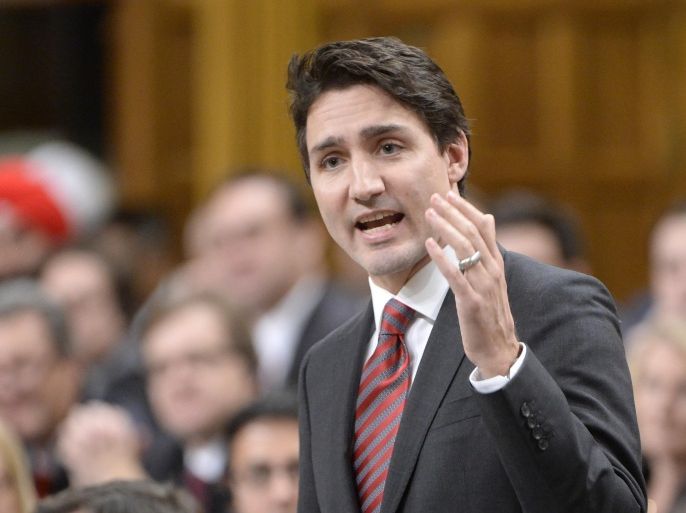 Prime Minister Justin Trudeau answers a question during question period in the House of Commons on Parliament Hill in Ottawa, on Wednesday, Dec. 9, 2015. The first two government flights carrying Syrian refugees to Canada will arrive this week, Trudeau announced Wednesday. (Adrian Wyld/The Canadian Press via AP)