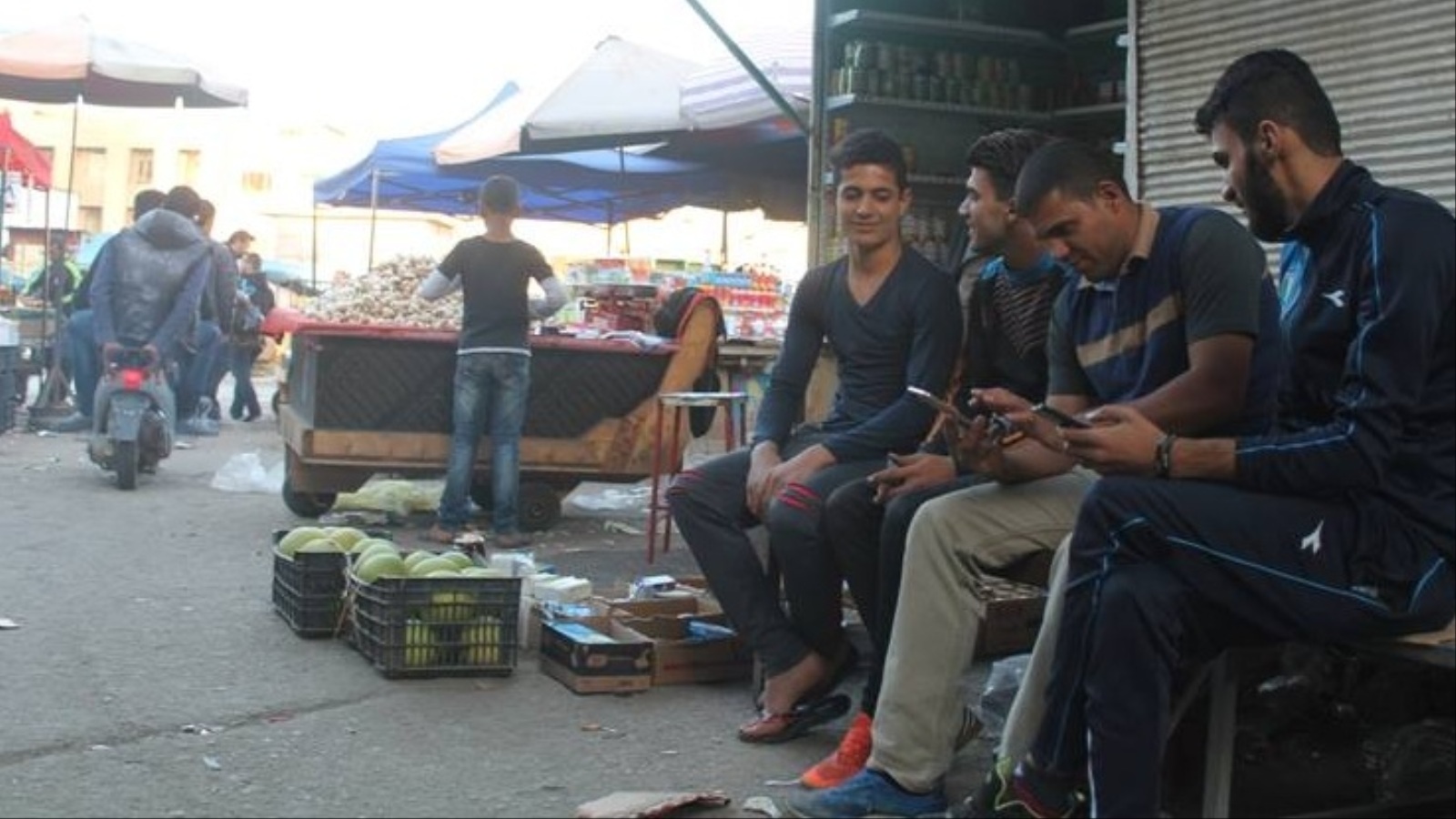 ‪شبان عراقيون عاطلون عن العمل في أحد أسواق بغداد‬ (الجزيرة)