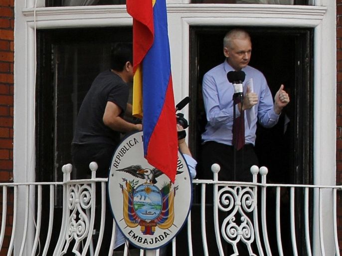 Wikileaks founder Julian Assange gestures as he speaks from the balcony of Ecuador's embassy, where he is taking refuge as a police officer stands guard beneath, in London in this file picture taken August 19, 2012. The Metropolitan Police have announced they are withdrawing their round the clock guard of the embassy. REUTERS/Chris Helgren