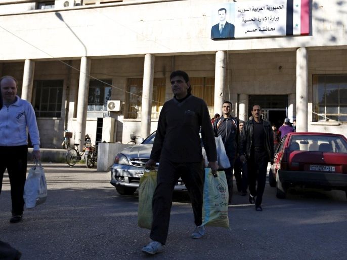 Newly released prisoners carry their belongings as they leave the Homs Governorate Council building, Syria December 7, 2015. Syrian authorities released more than 30 prisoners ahead of the implementation of a local ceasefire deal that is to include the withdrawal of opposition fighters from the last insurgent-held area of Homs with their weapons. REUTERS/Omar Sanadiki